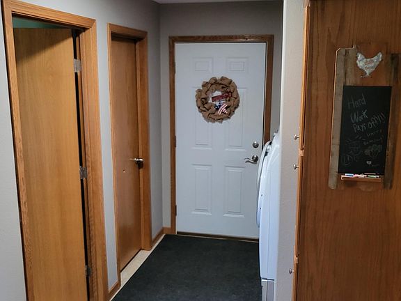 Hallway leads to garage, second bathroom on left, two rooms on right.