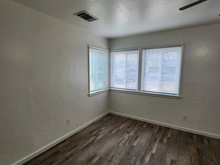 Living room with laminate flooring and ceiling fan.