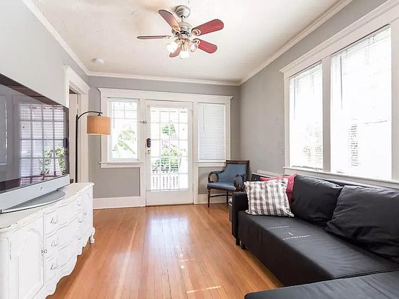 Bright natural light enters the living room. Hardwood floors