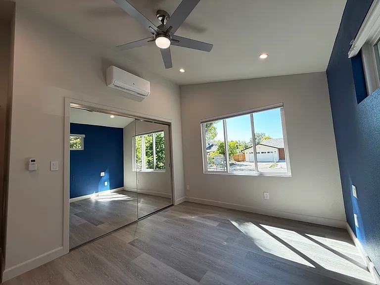 Main bedroom suite with vaulted ceilings, recessed lighting, overhead fan, blackout shades and large closet with built in cabinet organizer.