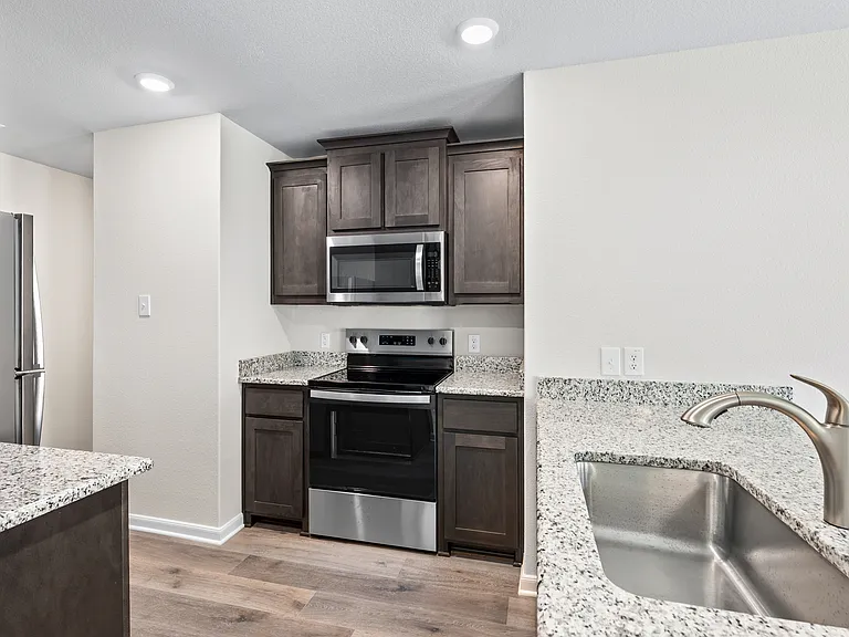 The kitchen has beautiful wood cabinets and stainless steel appliances.