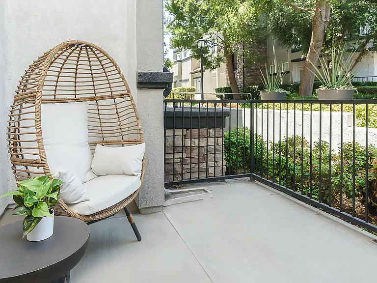 Peaceful Apartment Patio with Wicker Furniture and Greenery