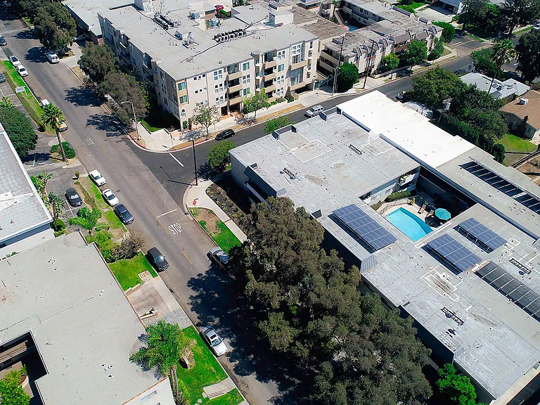 Aerial drone image of Rose Apartments and courtyard with pool.