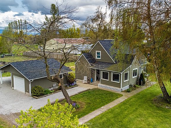 Aerial view of west side of house and detached garage with carport.