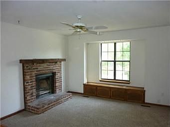 Brick Fireplace in Living Room with Ceiling Fan