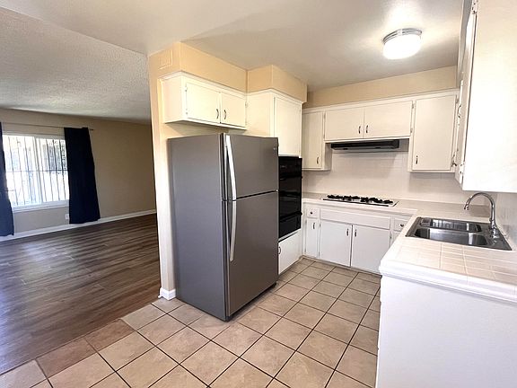 Kitchen with built-in gas cooktop, oven and refrigerator.