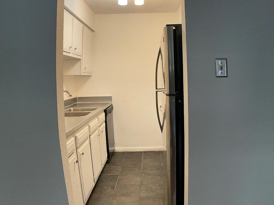 Stainless steel, white cabinets, and black accents galley kitchen.