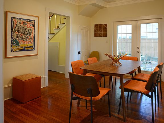 A view from Kitchen to Dining Room with the entry hall and stair to the left, covered Dining Porch beyond.