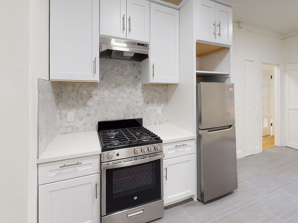 Kitchen with cabinets, refrigerator, stove, and range hood