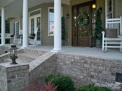 Enjoy the porch swing or rockers on the covered front porch. The beautiful front door is mahogany.