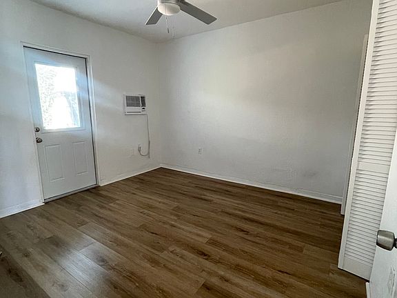 Bedroom with ceiling fan, door leading to fenced back area and closet.