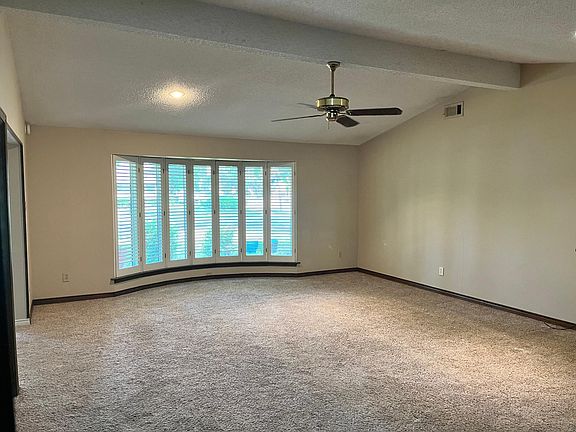 Great Room with vaulted ceiling and bay window with plantation shutters