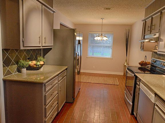 Kitchen With Brick Floors and New Stainless Steel Vent Hood