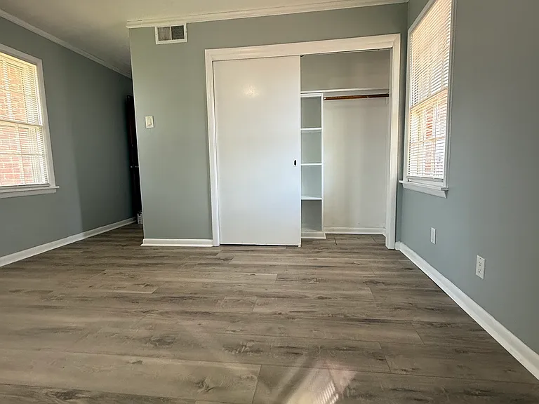 The master bedroom and sliding double door closet (one of two closets. the other is next to the window that leads into the hall.