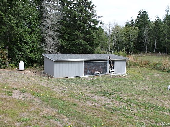 This is the garage - it fits one car currently, but does not have a garage door, so it's three-sided (open at one end). There is also shop space at the other end. There is a road to drive in the side yard and around to here.