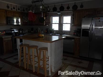 Kitchen
						:
						Ceramic tile floors and countertops. Butcher block island. Appliances stay.