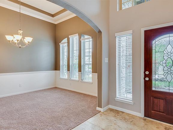 DINING ROOM WITH COFFERED CEILINGS OFF OF THE FOYER.