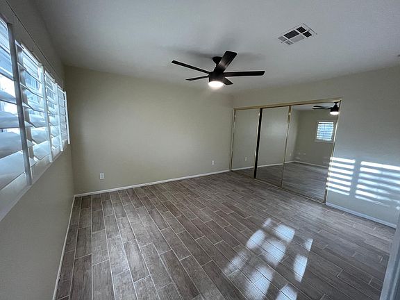 Master Bedroom with large sliding mirror closet doors...with natural light coming through plantation shutters