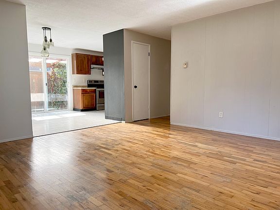 Living room leading to kitchen and hall, with coat and linen closets