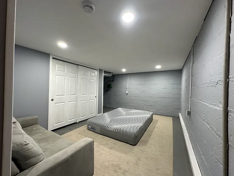 Downstairs finished basement bedroom with queen bed (frame to come) and couch.