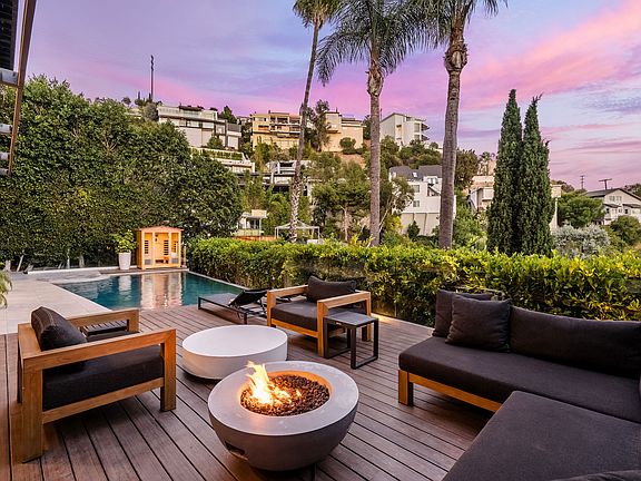 Highend outdoor seating with a gas firepit near the pool.
