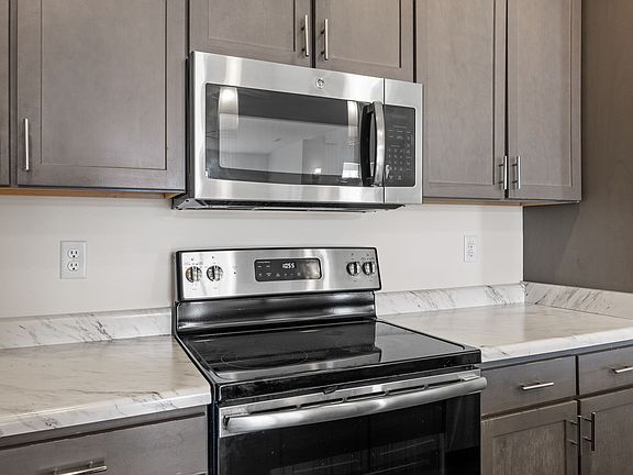 Stainless steel appliance with electric cooktop and oven; quartz countertops.