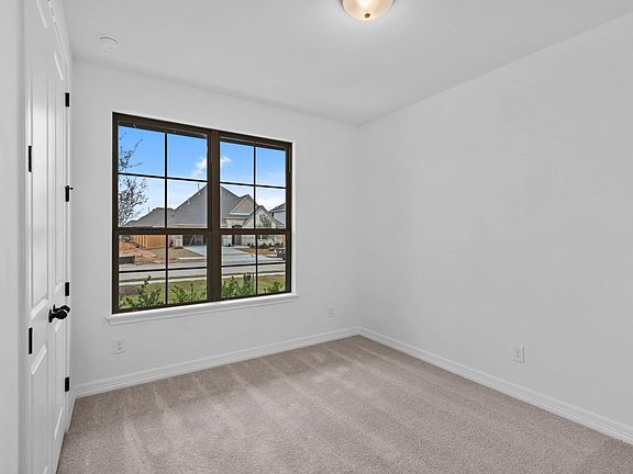 A secondary bedroom designed for comfort, featuring warm finishes and an easygoing feel.