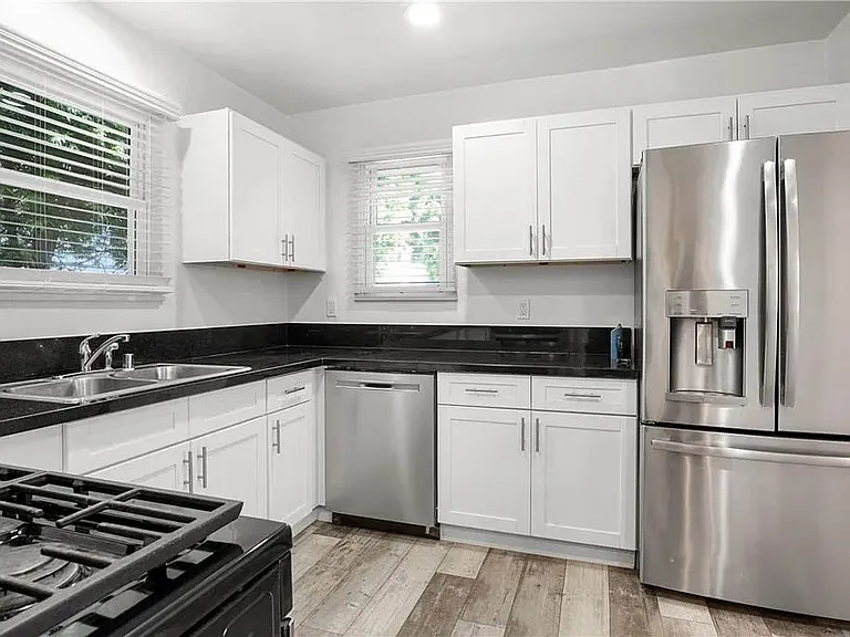 Beautifully updated kitchen with white shaker cabinetry, granite counters, brushed nickel pulls and handels, stainless appliances and more