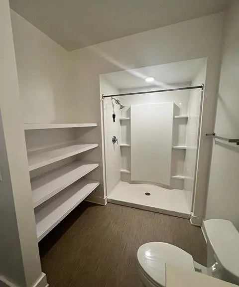 Spacious bathroom with oversized shower and large storage shelving