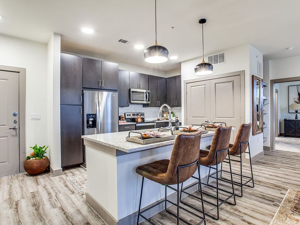Kitchen with espresso cabinetry, speckled granite countertops, white subway tile backsplash, stainless steel appliances, and hard surface flooring