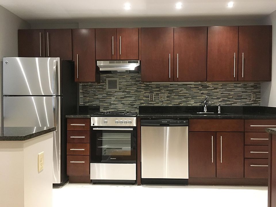 Custom designer kitchen with plenty of cabinets, granite counters, designer tiles, gas range, and stainless appliances.