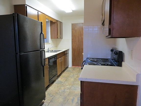 Kitchen showing door to half-bathroom/laundry room. Door to garage at end on right.