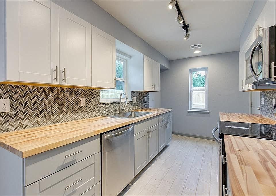 Kitchen includes a built-in microwave, beautiful butcher block countertops, with all new stainless appliances, sink and fixtures! New cabinetry and TONS of light! Includes refrigerator (not shown).