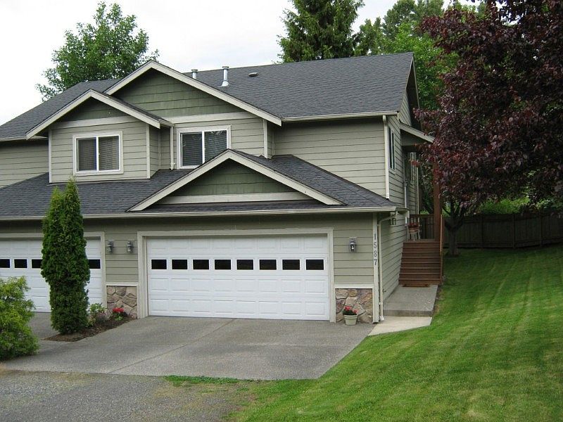 Front of the home showing large double garage, large side yard and fence around back.