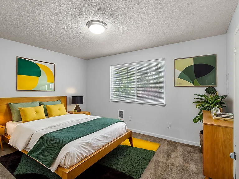 Experience tranquility in this stylishly designed bedroom featuring vibrant decor and natural light.