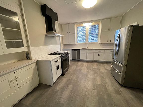 Modern kitchen with original built-ins. Stainless steel appliances, dishwasher and large sink.