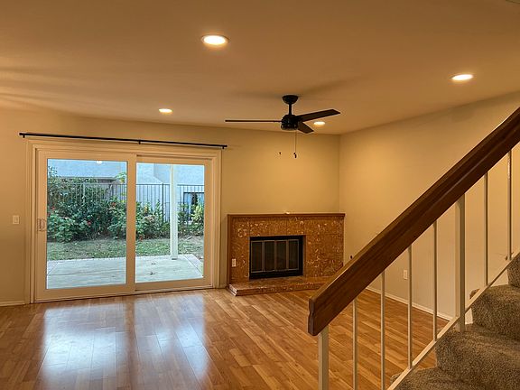 Living room with smooth ceilings, recessed and dimmable lights, ceiling fan and slider to backyard and covered patio.