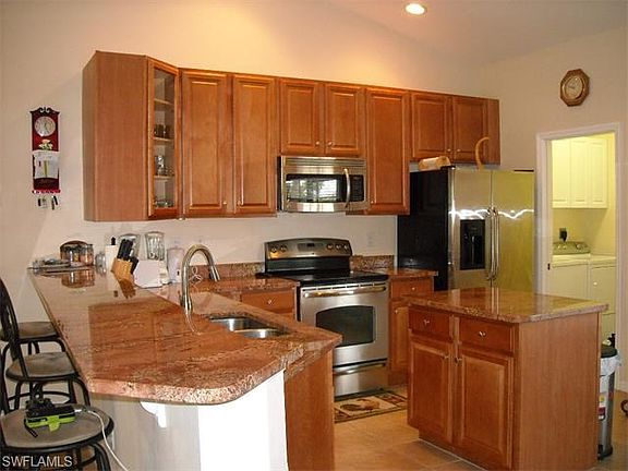 Solid surface granite counter tops, all stainless steel appliances; view toward laundry room.