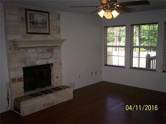 Family Room with a Gorgeous Stone Fireplace and Lots of Windows to the Back Yard
