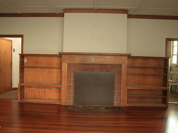 Living room - Left opening shows front door + hallway. Right opening shows kitchen.