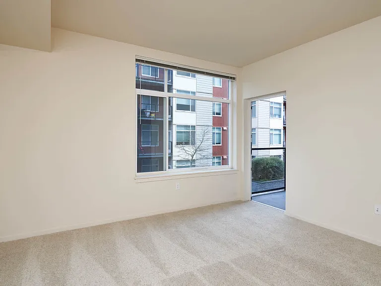Carpeted Living Room with Balcony