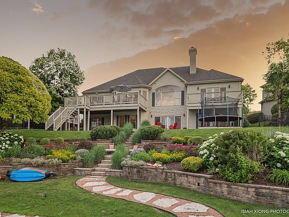 Professionally landscaped yard with terraced planters, sprinkler system and custom rock pathway to t