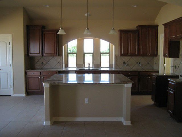 Open kitchen with granite counter top island bar