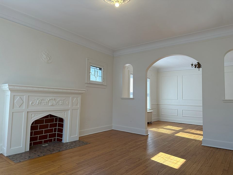 Living room with a "for decoration only" fireplace. Leaded glass decorative window. Beautiful hardwood floors.