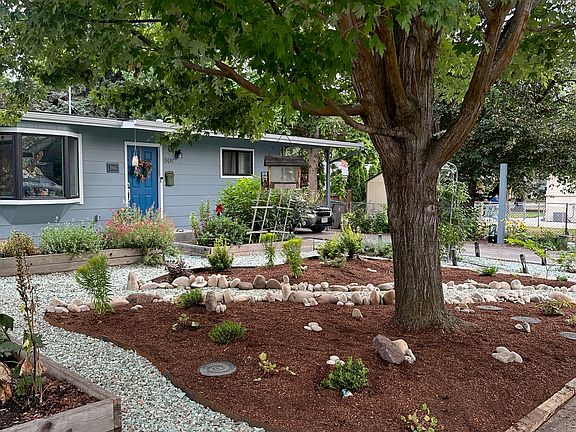 Front of the house with four raised beds.