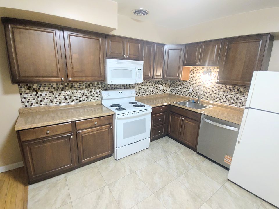 beautiful and spacious kitchen with glass tile backsplash and plenty of storage