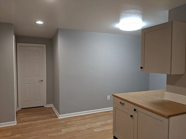 Upstairs, well lit living area with fridge. No oven. "Breakfast nook." Cupboards. Great for studying, crafts area;