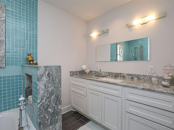 Carrera marble counters, backslash, window trim, etc is set off with colorful glass tile. Note the unique light fixtures and contemporary mirror.