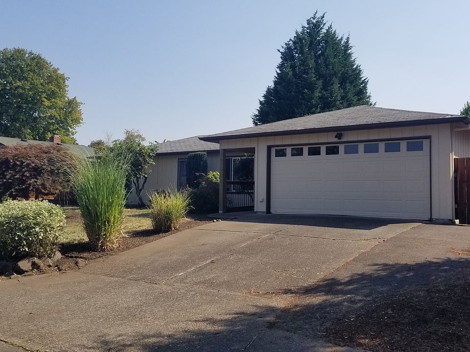 Front of house, covered entry, wide driveway, fence and gate
