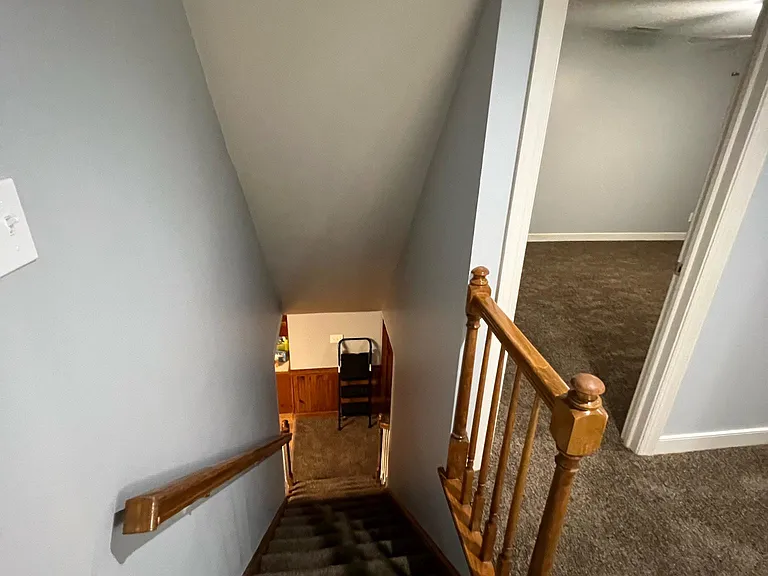 Photo looking downstairs from the top of the stairwell and looking into bedroom 1